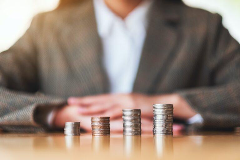 Businesswoman stacking coins on the table for saving money concept